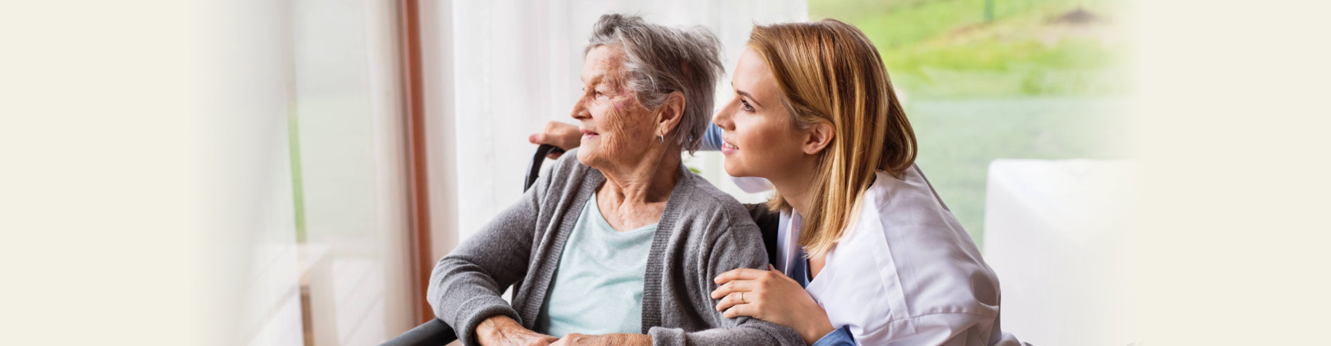 caregiver and an elderly woman watching something outside